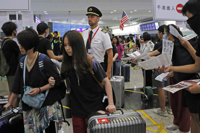 Passengers and flight crew arrive at Hong Kong International Airport, Monday, Aug. 12, 2019. Photo: Kin Cheung / AP