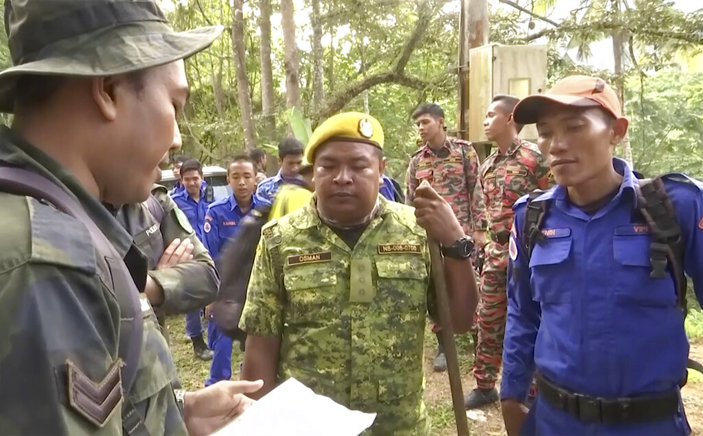 In this image from a video, rescuers brief as they conduct a search and rescue operation for a missing British girl at a forest in Seremban, Malaysia Tuesday, Aug. 13, 2019. Photo: AP