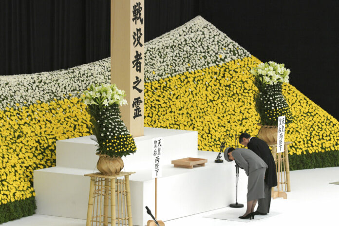 Japanese Emperor Naruhito, accompanied by Empress Masako bows after delivering a speech before the main altar decorated with huge bank of chrysanthemums during a memorial ceremony for the war dead at Nippon Budokan Martial Arts Hall in Tokyo Thursday, Aug. 15, 2019. Photo: Eugene Hoshiko / AP