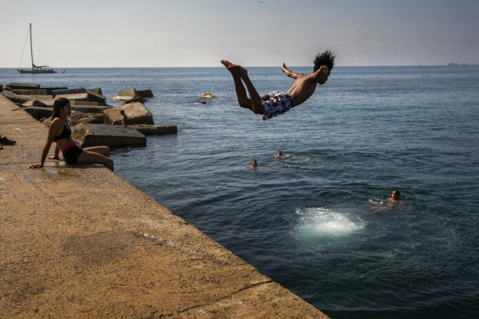 FILE - In this file photo dated Thursday, July 25, 2019, a boy jumps into the water at the beach in Barcelona, Spain. The U.S. National Oceanic and Atmospheric Administration said Thursday Aug. 15, 2019, that July was the hottest month measured on Earth since records began in 1880. Photo: Emilio Morenatti / AP File