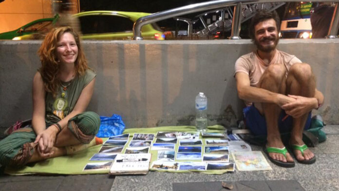 A pair of begpackers selling travel photos by the BTS Mo Chit stairs on Jan. 16, 2016. Photo: Pornthip Chaithanapat / Facebook