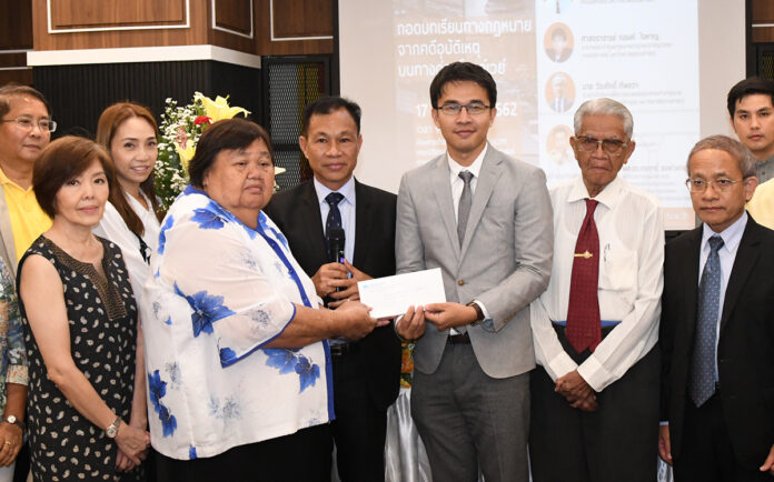 Thawin Chaotiang hands a donation to staff Aug. 17., 2019 at the Law Center at Thammasat University.