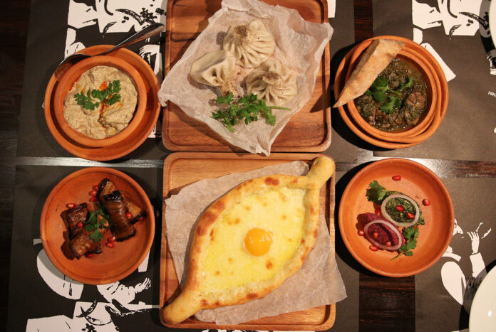 Clockwise from top left: satsivi (190 baht), khinkhali (70 baht apiece), chakapuli (470 baht), phali (120 baht), acharuli khachapuri (250 baht), and badrijani nigvzit (130 baht).