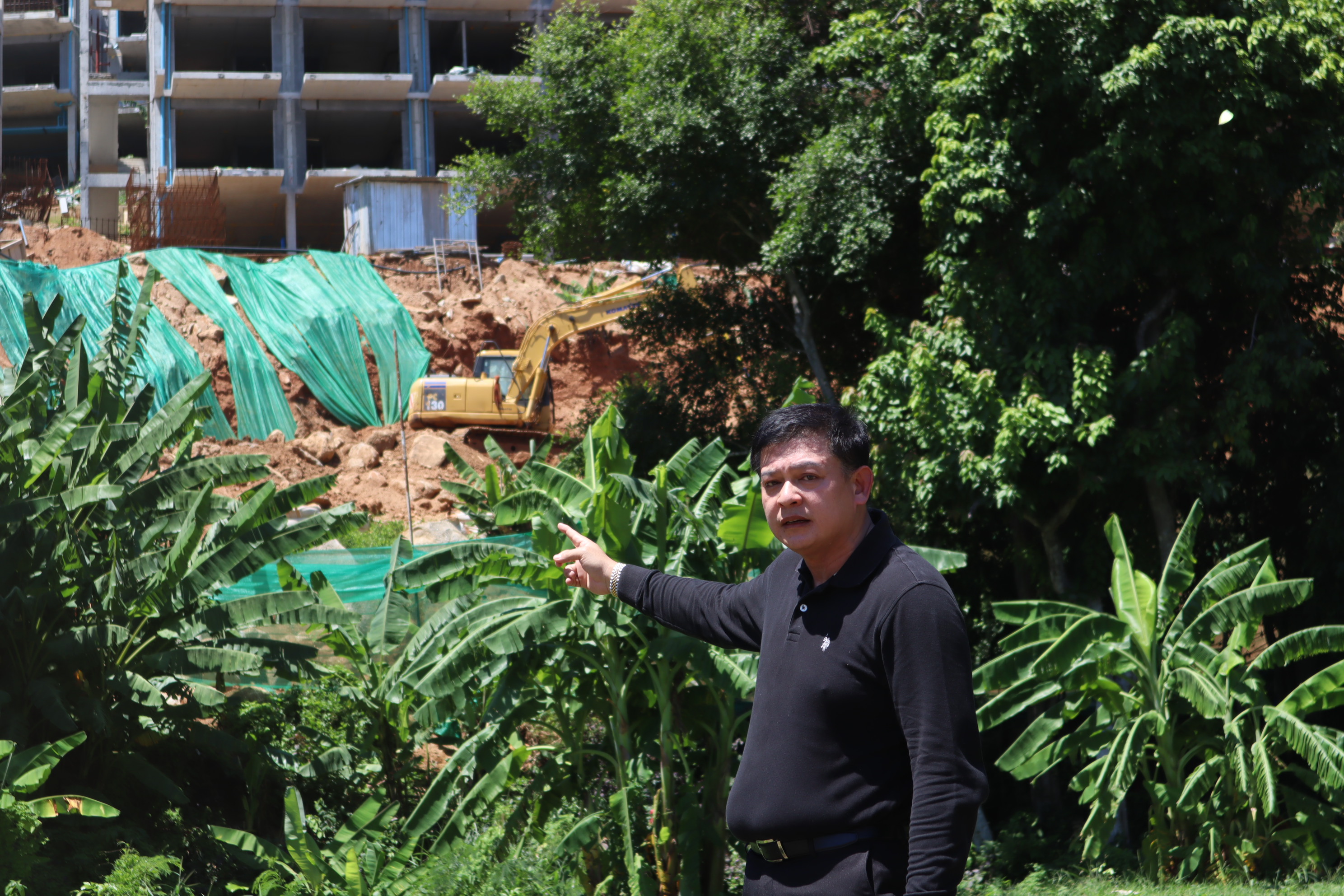 Sira pointing at the controversial condominium project in Phuket on Aug. 18.