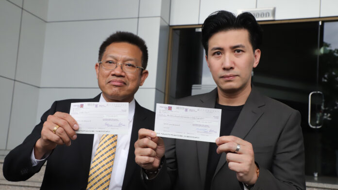 Decha Kittivittayanan, left, and Kanchai “Noom” Kamnerdploy, right, holding the cheques for compensation in front of the Civil Court on August 6. Decha Kittivittayanan, left, and Kanchai “Noom” Kamnerdploy, right, holding the cheques for compensation in front of the Civil Court on August 6.