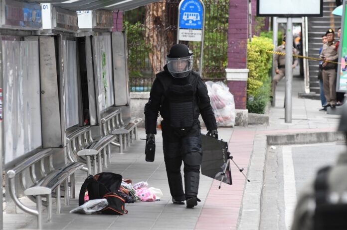 EOD police inspect a suspected explosive device at a bus stop in Bangkok on Aug. 3, 2019. It turned out to be a false alarm.