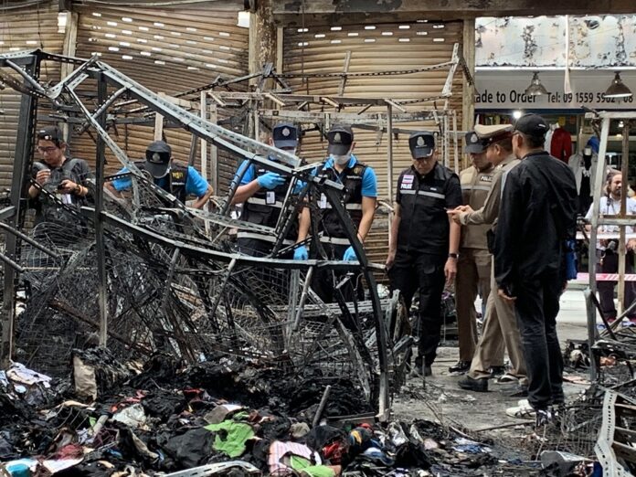 Forensic police inspect a shop attacked by a firebomb in Pratunam neighborhood of Bangkok on Aug. 3, 2019.