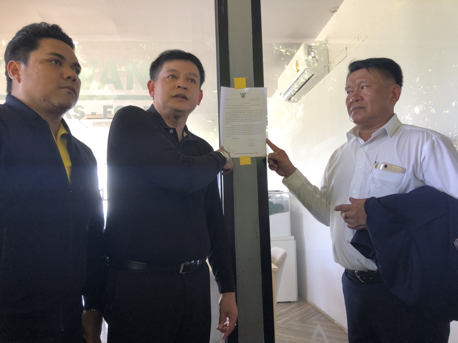 Sira pointing at a construction suspension notice inside the sales office of the condominium on Aug. 18. 