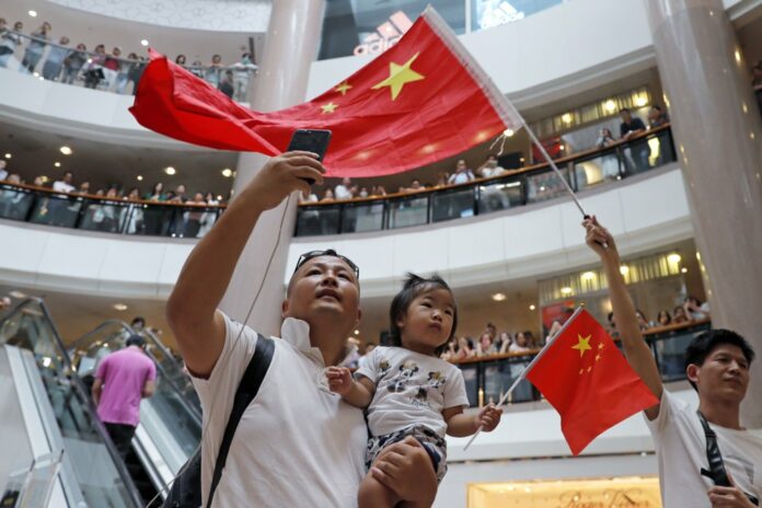 Pro-China supporters wave Chinese national flag in a shopping mall in Hong Kong, Wednesday, Sept. 18, 2019. (AP Photo/Kin Cheung)