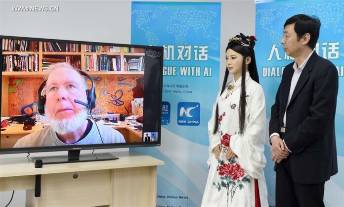 Chen Xiaoping (R), director of a robot research and development team, and Jia Jia, an interactive robot that looks like a real Chinese young woman in traditional outfit, talk through internet with Kevin Kelly on screen, founding executive editor of Wired magazine, in Hefei, capital of east China's Anhui Province, April 24, 2017. Jia Jia was invited as a special reporter of the Xinhua News Agency to conduct the man-machine dialogue with Kelly on Monday. Jia Jia was unveiled in 2016 by Chen's robot research and development team at the University of Science and Technology of China in Hefei. It took the team three years to research and develop this new-generation interactive robot, which can speak, show micro-expressions, move its lips, and move its body. Photo: Guo Chen / Xinhua