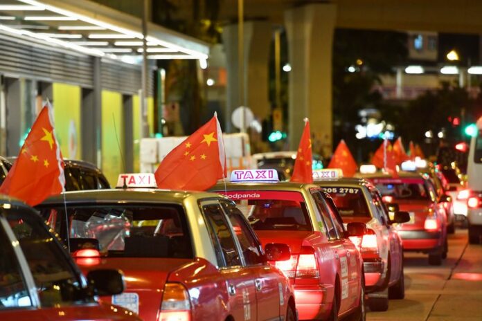 Taxis hanging China's national flags rally on the main streets of Hong Kong on Aug. 23, 2019. Photo: Liu Dawei / Xinhua