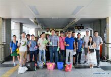 Hong Kong Citizens, Armed with Detergent, Clean Up After Protesters Photo taken on Sept. 1, 2019 shows volunteers posing for a group photo after cleaning a pedestrian bridge near Wan Chai metro station in south China's Hong Kong. Recently, Hong Kong had some chaotic nights when rioters threw petrol bombs, set fire on roads, hurled bricks and vandalized shops and metro stations. When residents go out the next morning, they will find few traces of the tumultuous nights on the streets. A group of volunteers known as the scar removers are among the many people who have contributed to the rapid tidying-up of the ravaged streets. Photo: Mao Siqian / Xinhua