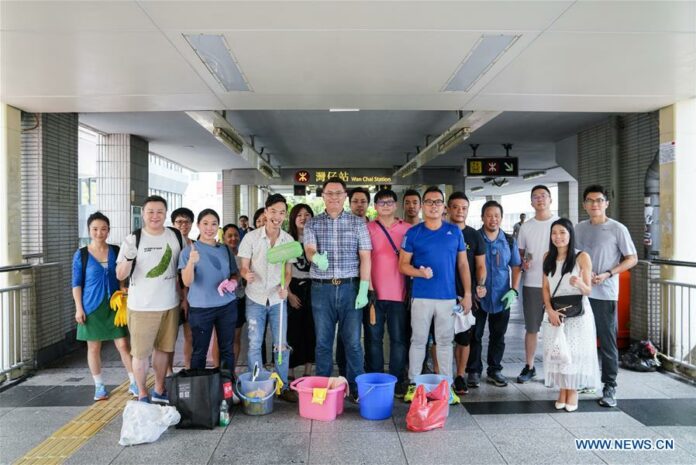 Photo taken on Sept. 1, 2019 shows volunteers posing for a group photo after cleaning a pedestrian bridge near Wan Chai metro station in south China's Hong Kong. Recently, Hong Kong had some chaotic nights when rioters threw petrol bombs, set fire on roads, hurled bricks and vandalized shops and metro stations. When residents go out the next morning, they will find few traces of the tumultuous nights on the streets. A group of volunteers known as the scar removers are among the many people who have contributed to the rapid tidying-up of the ravaged streets. Photo: Mao Siqian / Xinhua