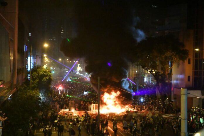 Protesters shine laser beams and set fires near the Hong Kong police headquarters in Wan Chai in the HKSAR, Aug. 31, 2019. Photo: Xinhua