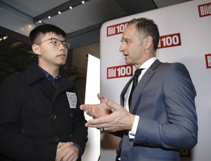 German Foreign Minister Heiko Maas, right, talks to Hong Kong activist Joshua Wong, left, during a reception of a German news paper in Berlin, Germany, Monday, Sept. 9, 2019. (Michael Kappeler/dpa via AP)