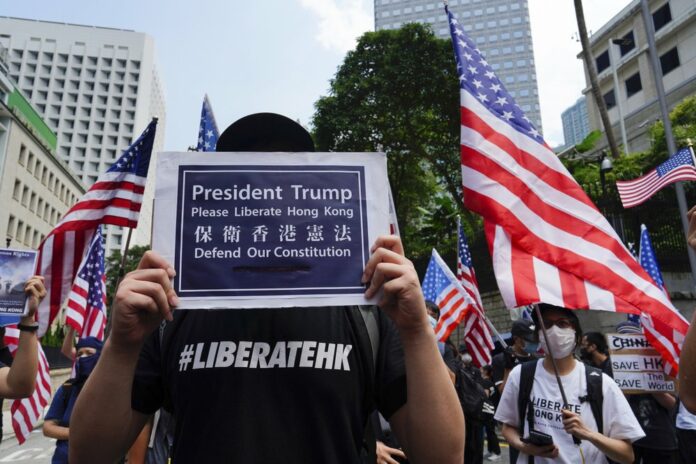 Protesters waves United States flags and placards during a protest in Hong Kong, Sunday, Sept. 8, 2019. (AP Photo/Vincent Yu)