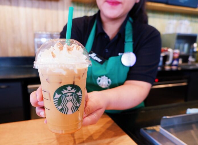 A Starbucks barista holds a Pumpkin Spice Latte on Sept. 18, 2019 in Bangkok.