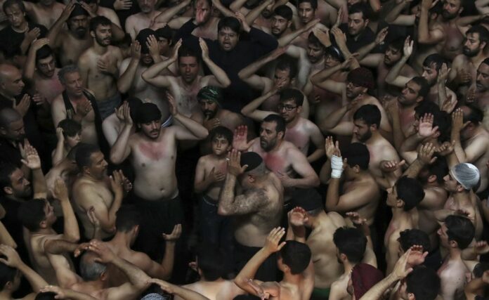 Iranian and Iraqi Shiite Muslims beat their heads during a mourning ceremony marking Ashoura in downtown Tehran, Iran, Tuesday, Sept. 10, 2019. (AP Photo/Vahid Salemi)