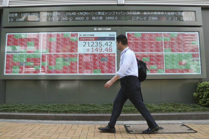 A man walks by an electronic stock board of a securities firm in Tokyo, Friday, Sept. 6, 2019. Asian shares rose Friday as investors cheered plans for more trade negotiations between Washington and Beijing and drew encouragement from positive data about the U.S. economy. Photo: Koji Sasahara / AP