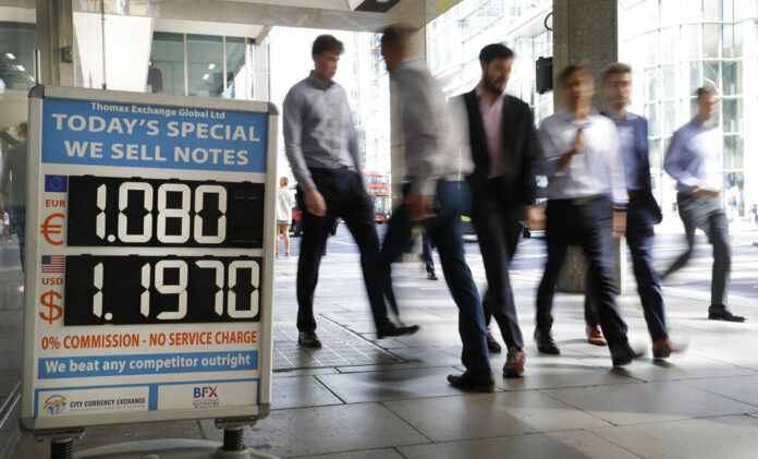 Pedestrians pass a currency exchange board in London, Thursday, Aug. 29, 2019. Critics of Britain's prime minister are reacting with fury after he got Queen Elizabeth's approval to suspend Parliament. The move by Boris Johnson means his political opponents have less time to block a chaotic no-deal Brexit before the Oct. 31 withdrawal deadline. Photo: Kirsty Wigglesworth / AP Pedestrians pass a currency exchange board in London, Thursday, Aug. 29, 2019. Critics of Britain's prime minister are reacting with fury after he got Queen Elizabeth's approval to suspend Parliament. The move by Boris Johnson means his political opponents have less time to block a chaotic no-deal Brexit before the Oct. 31 withdrawal deadline. Photo: Kirsty Wigglesworth / AP