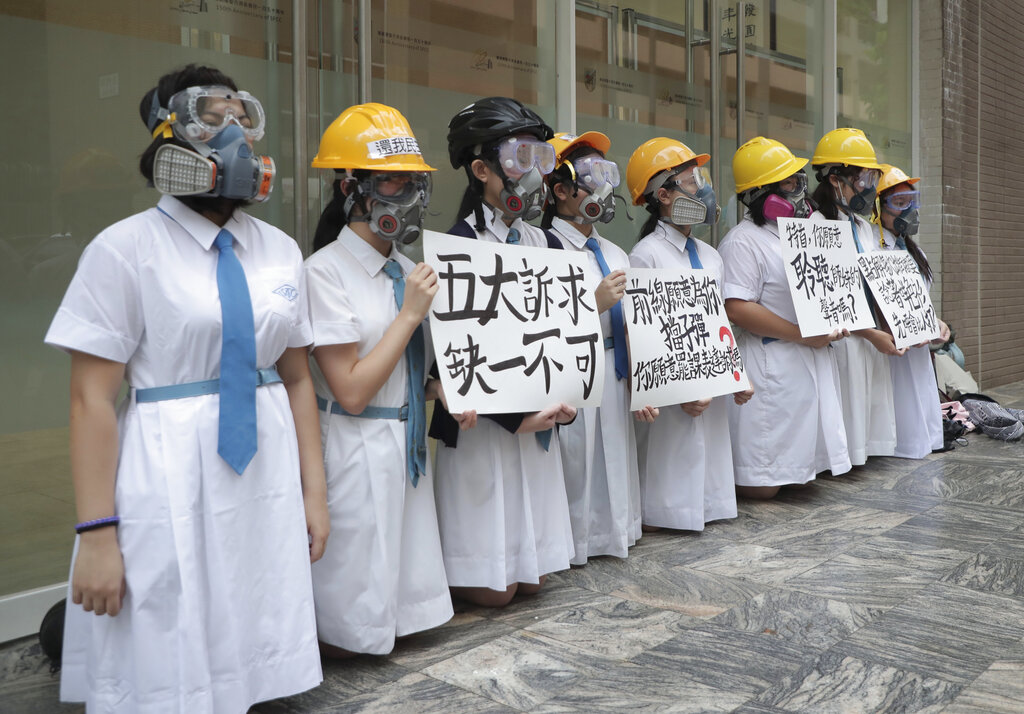 Students wearing gas masks and helmets hold a banner which reads "Five major demands are indispensable.", at St. Francis' Canossian College in Hong Kong, on Monday, Sept. 2, 2019. Hong Kong has been the scene of tense anti-government protests for nearly three months. The demonstrations began in response to a proposed extradition law and have expanded to include other grievances and demands for democracy in the semiautonomous Chinese territory. Photo: AP