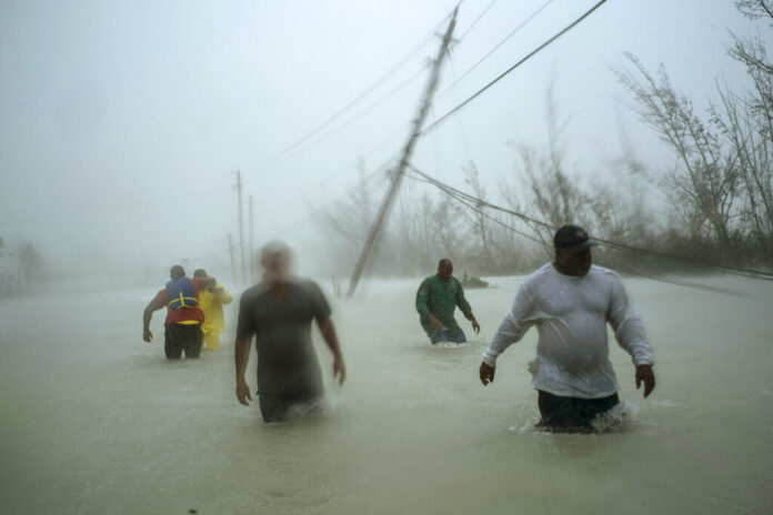 Volunteers walk under the wind and rain from Hurricane Dorian through a flooded road as they work to rescue families near the Causarina bridge in Freeport, Grand Bahama, Bahamas, Tuesday, Sept. 3, 2019. The storm’s punishing winds and muddy brown floodwaters devastated thousands of homes, crippled hospitals and trapped people in attics. Photo: Ramon Espinosa / AP Volunteers walk under the wind and rain from Hurricane Dorian through a flooded road as they work to rescue families near the Causarina bridge in Freeport, Grand Bahama, Bahamas, Tuesday, Sept. 3, 2019. The storm’s punishing winds and muddy brown floodwaters devastated thousands of homes, crippled hospitals and trapped people in attics. Photo: Ramon Espinosa / AP