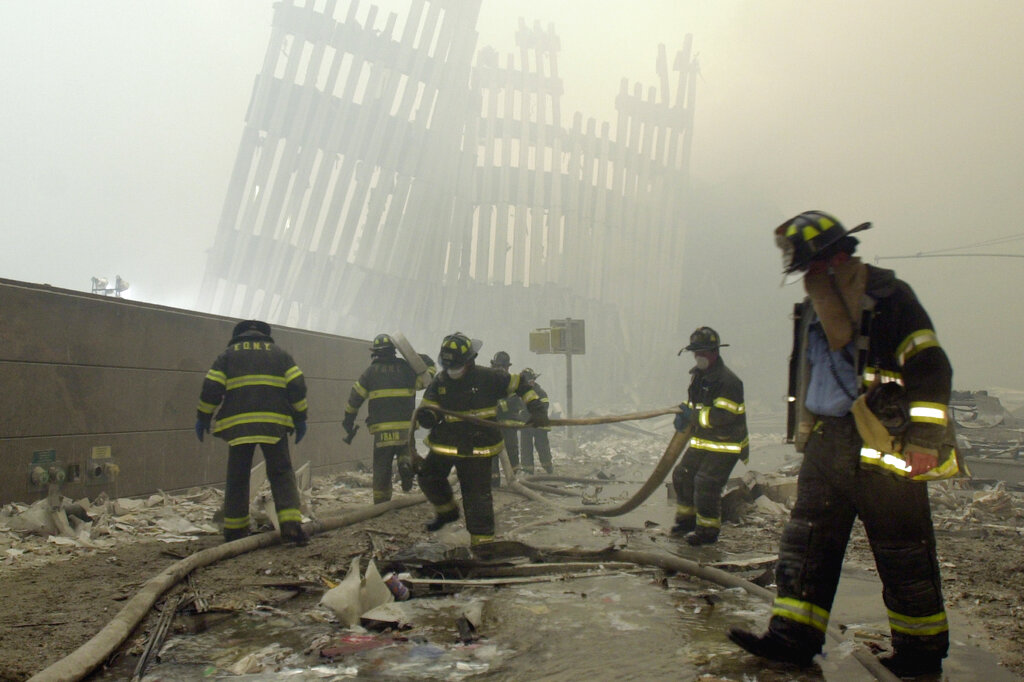In this Sept. 11, 2001, file photo, firefighters work beneath the destroyed mullions, the vertical struts that once faced the outer walls of the World Trade Center towers, after a terrorist attack on the twin towers in New York. Sept. 11 victims’ relatives are greeting the news of President Donald Trump’s now-canceled plan for secret talks with Afghanistan’s Taliban insurgents with mixed feelings. Photo: Mark Lennihan / AP