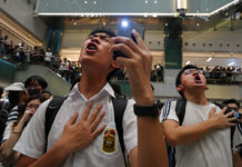 Protesters Belt out Karaoke in New Hong Kong Protest Method Local residents sing a theme song written by protesters "Glory be to thee" at a shopping mall in Hong Kong Wednesday, Sept. 11, 2019. Photo: Vincent Yu / AP