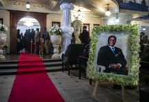 Few Turn out as Mugabe Is Returned to a Zimbabwe in Crisis A portrait of former president Robert Mugabe stands outside the room where his body lies in state inside his official residence in the capital Harare, Zimbabwe Wednesday, Sept. 11, 2019. Photo: Ben Curtis / AP