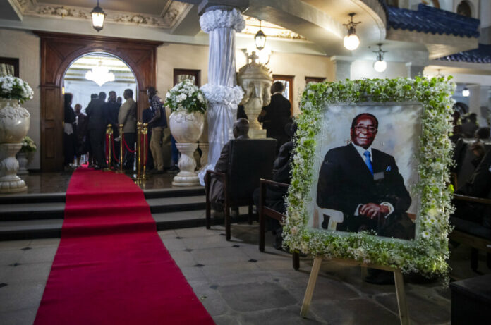 A portrait of former president Robert Mugabe stands outside the room where his body lies in state inside his official residence in the capital Harare, Zimbabwe Wednesday, Sept. 11, 2019. Photo: Ben Curtis / AP