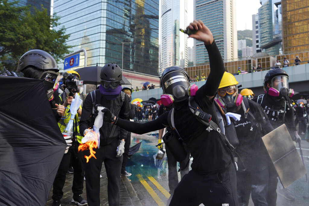 An anti-government protester throws a Molotov cocktail during a demonstration near Central Government Complex in Hong Kong, Sunday, Sept. 15, 2019. Police fired a water cannon and tear gas at protesters who lobbed Molotov cocktails outside the Hong Kong government office complex Sunday, as violence flared anew after thousands of pro-democracy supporters marched through downtown in defiance of a police ban. Photo: Vincent Yu / AP