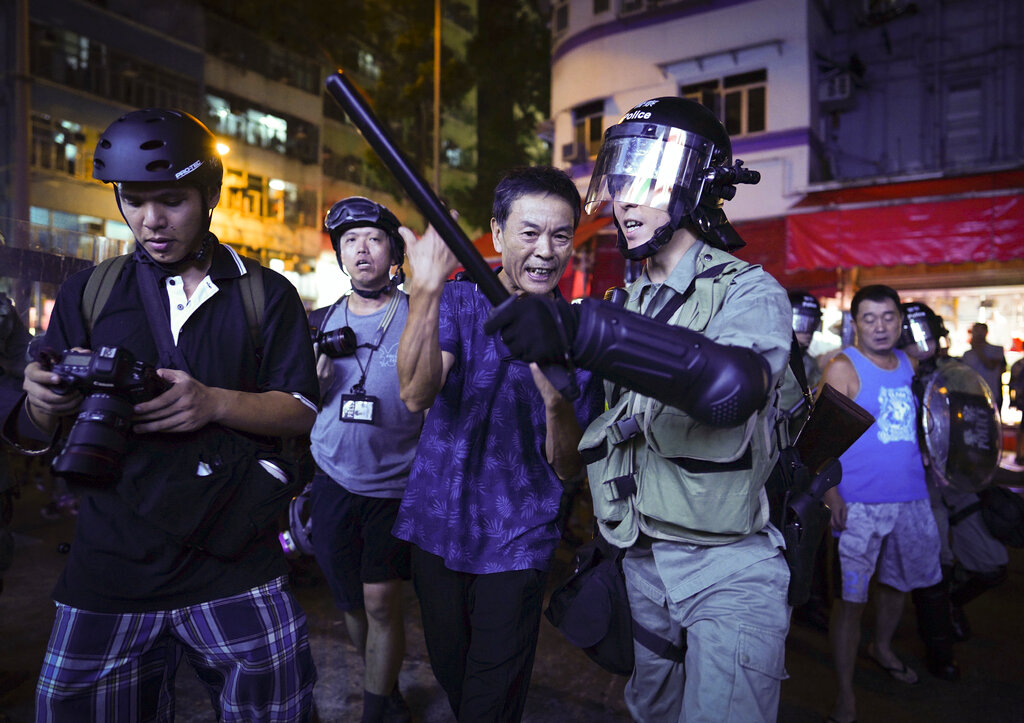 A Pro-China supporter, center, is escorted by police after confronting journalists in north point, Hong Kong, Sunday, Sept. 15, 2019. Police fired a water cannon and tear gas at protesters who lobbed Molotov cocktails outside the Hong Kong government office complex Sunday, as violence flared anew after thousands of pro-democracy supporters marched through downtown in defiance of a police ban. Photo: Vincent Yu / AP