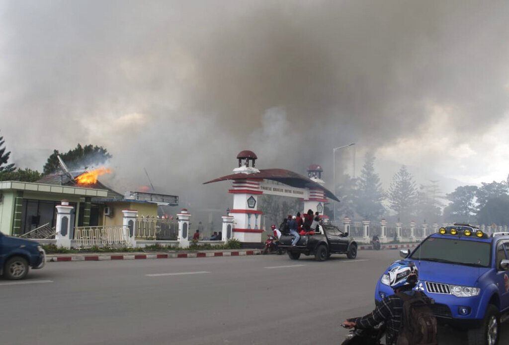 Residents drive past a burning government building in Wamena, Papua province, Indonesia, Monday, Sept. 23, 2019.  Hundreds of protesters in Indonesia's restive Papua province set fire to homes and other buildings Monday in a protest sparked by rumours that a teacher had insulted students. Photo: George Yewun / AP