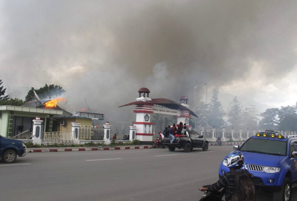 Residents drive past a burning government building in Wamena, Papua province, Indonesia, Monday, Sept. 23, 2019. Hundreds of protesters in Indonesia's restive Papua province set fire to homes and other buildings Monday in a protest sparked by rumours that a teacher had insulted students. Photo: George Yewun / AP