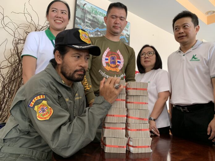 Bin Banluerit, left, receives a cash donation on Sept. 18, 2019 in Ubon Ratchathani.