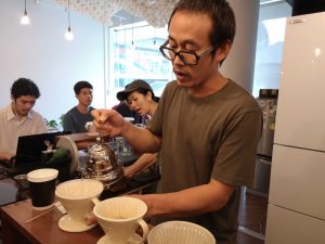 Piyachat making a cup of drip coffee.