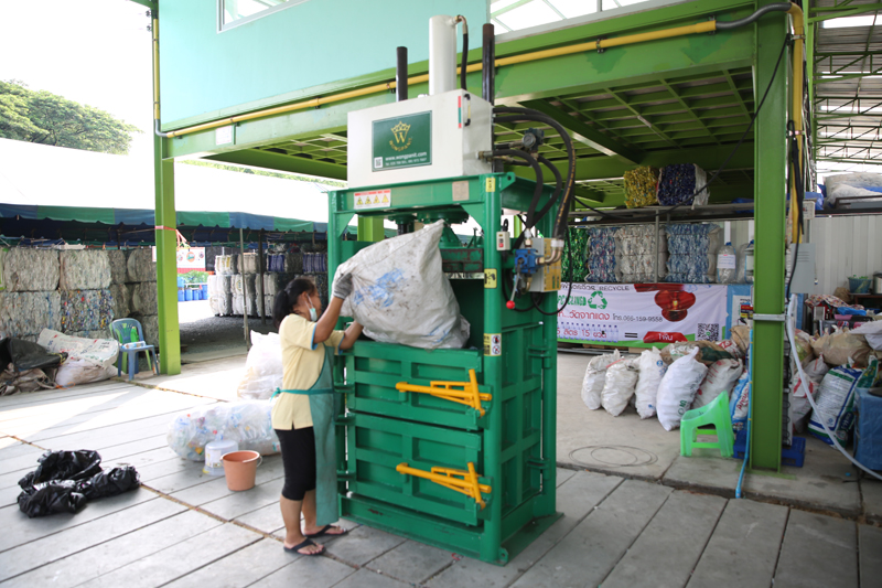 Plastic bottles being loaded into compressing machine.