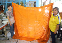 This Temple Recycles Plastic Bottles Into Monk Robes Volunteers showing a piece of robe made from recycled fibers.