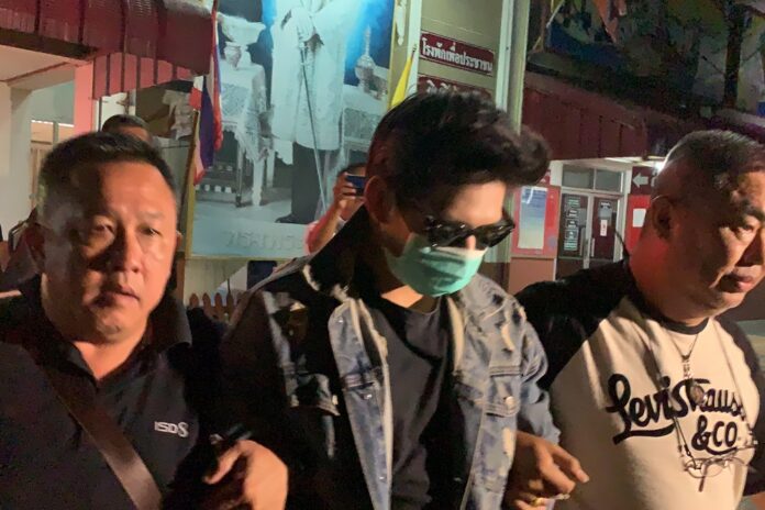 Rachadech Wongtabutr is flanked by police officers shortly after his arrest on Sep. 25, 2019.