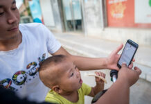 Number of Chinese Online Readers Reaches 455 Millions Villager Li Yongchang shows online shopping websites to his son in Liulin Village, Xingtai City of north China's Hebei Province. Photo: Liu Bin / Xinhua