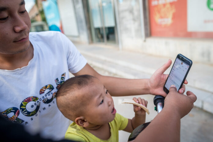 Villager Li Yongchang shows online shopping websites to his son in Liulin Village, Xingtai City of north China's Hebei Province. Photo: Liu Bin / Xinhua