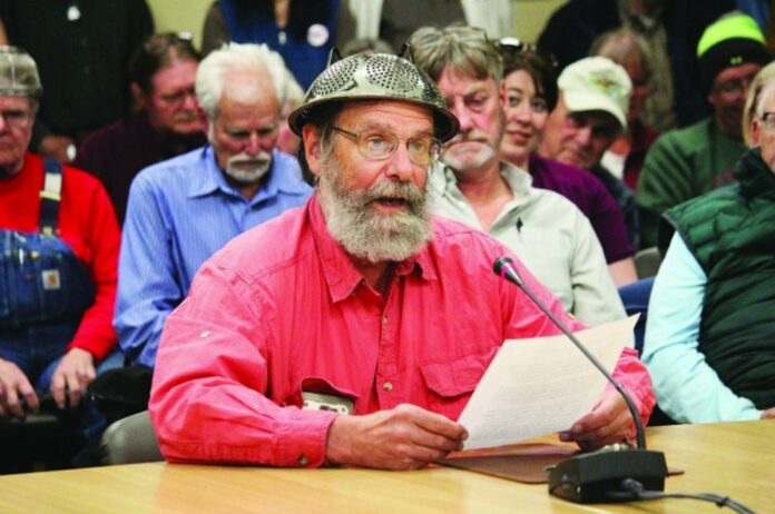 Fritz Creek area resident Barrett Fletcher gives the invocation before a Kenai Peninsula Borough Assembly meeting as a representative of the Church of the Flying Spaghetti Monster at Homer City Hall in Homer, Alaska, Tuesday, Sept. 18, 2019. (Megan Pacer/Homer News via AP)