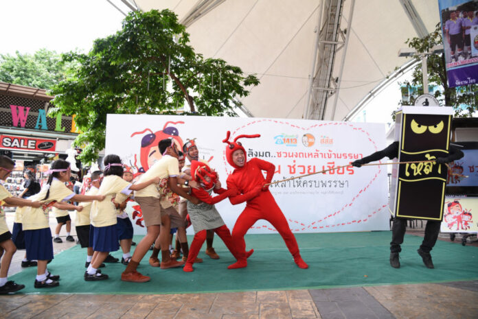 Students playing tug of war with a liquor mascot during an anti-alcohol event at the Victory Monument on July 31, 2018.
