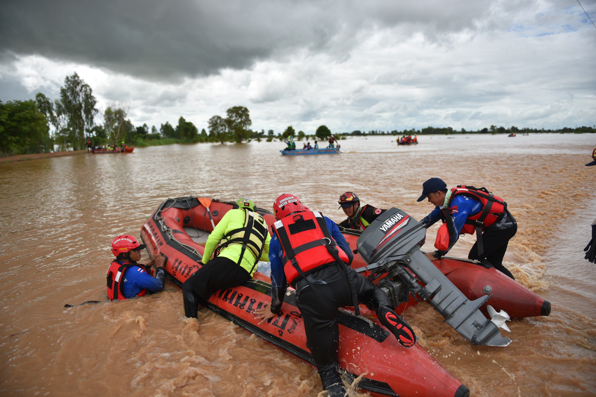 Rescuers pushing inflatable boat through currents in Phitsanulok's Wang Thong district on Sept. 2.