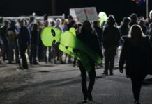 Are We Alone in the Universe? Experts to Weigh in at Bangkok, Chiang Mai Event A man holds an inflatable alien at an entrance to the Nevada Test and Training Range near Area 51 Friday, Sept. 20, 2019, near Rachel, Nev. People gathered at the gate inspired by the "Storm Area 51" internet hoax. Photo: John Locher / AP
