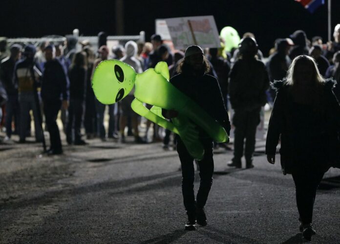 A man holds an inflatable alien at an entrance to the Nevada Test and Training Range near Area 51 Friday, Sept. 20, 2019, near Rachel, Nev. People gathered at the gate inspired by the 