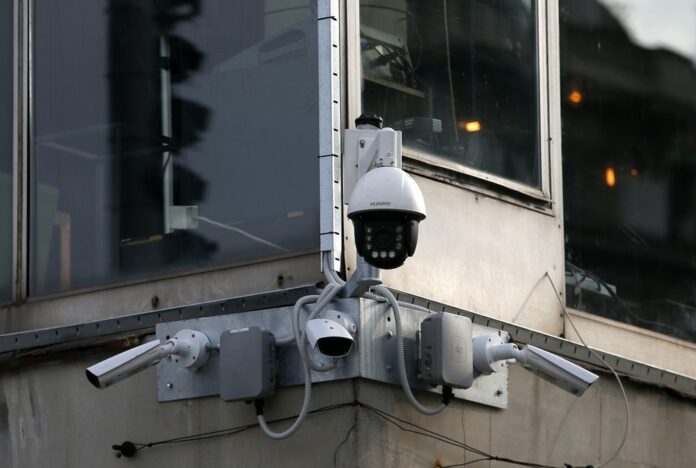 In this photo taken Sept. 25, 2019, high-tech video cameras hang from an office building in downtown Belgrade, Serbia. (AP Photo/Darko Vojinovic)