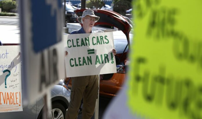 Paul Gipe protests before the first of three public hearings on the Trump administration's proposal to roll back car-mileage standards in a region with some of the nation's worst air pollution Monday, Sept. 24, 2018 in Fresno, Calif. (AP Photo/Gary Kazanjian)