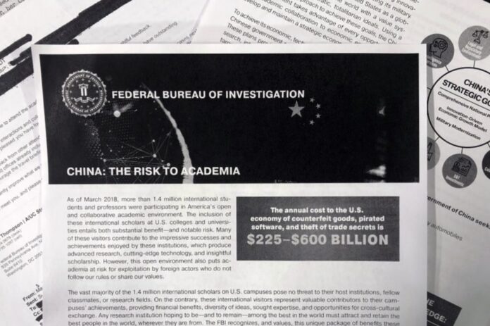 This Oct. 4, 2019 photo shows a copy of an FBI pamphlet and related emails. The FBI’s outreach to American colleges and universities about the threat of economic espionage includes this pamphlet that warns specifically about efforts by China to steal academic research. (AP Photo)