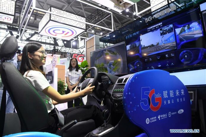 A staff member shows a 5G-based remote driving technology during the 2019 Smart China Expo in southwest China's Chongqing Municipality, Aug. 26, 2019. The 2019 Smart China Expo kicked off Monday at the Chongqing International Expo Center. High techs including 5G live broadcast and 5G remote emergency medical aid are among the expo's highlights. (Xinhua/Tang Yi)